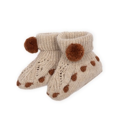 Meias de bebé em malha bege com pompons castanhos e pontos decorativos.