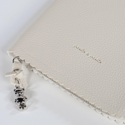 Capa bege clara em couro com pendente de ursinho metálico