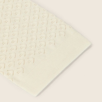 Manga de malha creme com padrão de losangos perforados