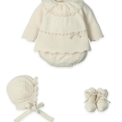 Conjunto de bebé bege em malha composto por vestido, bombazine, gorro e sapatinhos.