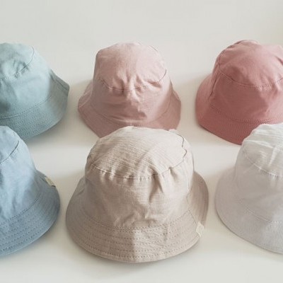 Seis chapéus bucket hats coloridos sobre uma superfície branca
