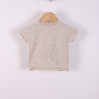 Camisola de malha bege infantil com mangas curtas pendurada