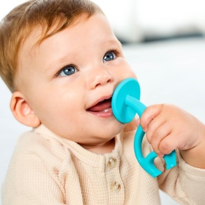 Bebé com chocalho azul a morder