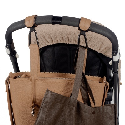 Carrinho de bebé com duas bolsas penduradas, uma castanha clara e outra castanha escura