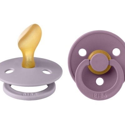 Duas chupetas BIBS lilás e amarelas sobre fundo branco