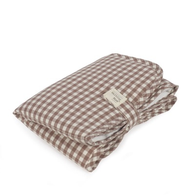 Colcha xadrez castanho e branco dobrada com etiqueta WOLLENBURG Made in Germany