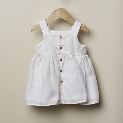 Vestido infantil branco com botões em cabide de madeira
