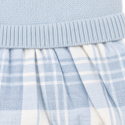 Peça de roupa infantil azul clara com padrão aos quadrados.