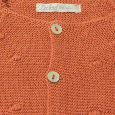 Casaco laranja de malha com botões brancos e etiqueta 'Darkred Amber M'.