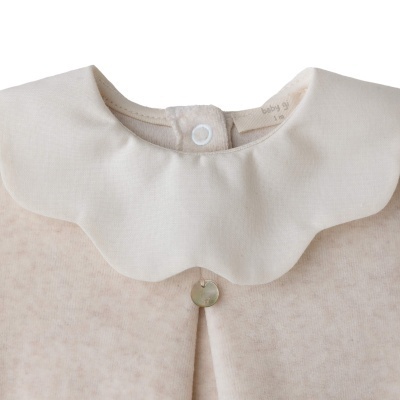 Roupa de bebé bege claro com gola branca e botão dourado decorativo