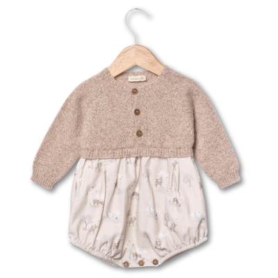 Macacão de bebé bege com padrão de animais, pendurado em cabide de madeira