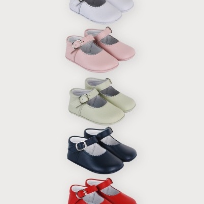 Cinco pares de sapatos de bebé coloridos com fivela lateral, em fundo branco