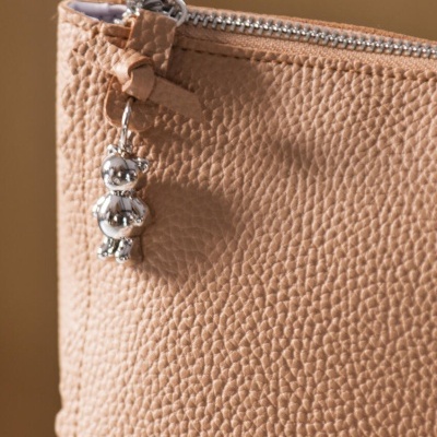 Bolsa bege texturizada com fecho e pendente prateado