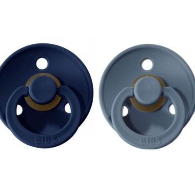 Duas chupetas BIBS, azul escura e cinza clara, com partes castanhas