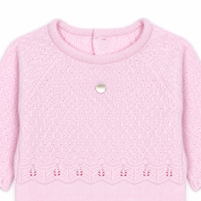 Camisola rosa de malha com padrão e pendente redondo prateado no centro.