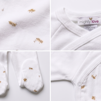 Roupa de bebé branca com padrão dourado e etiqueta mighty love