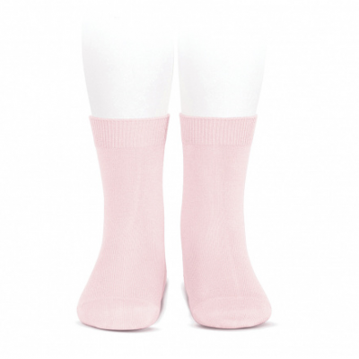 Meias cor-de-rosa em tecido liso apresentadas num manequim sobre fundo branco