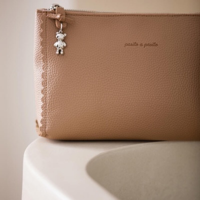 Necessaire castanho claro com pendente de ursinho metálico e texto 'panito e panito'
