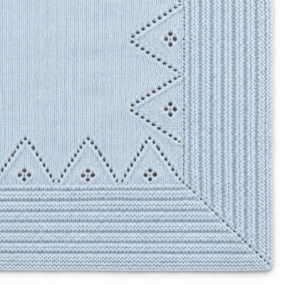 Pano têxtil azul claro com padrão tricotado em linha e triângulos perfurados