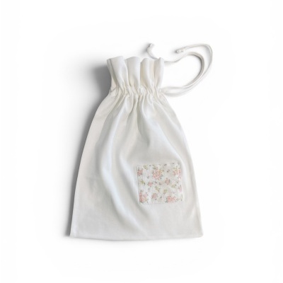 Saco de tecido branco com bolso floral e cordão de fecho