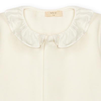 Roupa de bebé creme com gola franzida branca e etiqueta baby gi 1 m