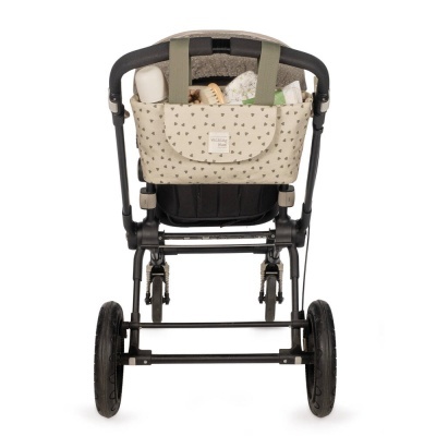 Carrinho de bebé preto com bolsa bege decorada com pequenas estrelas e itens dentro