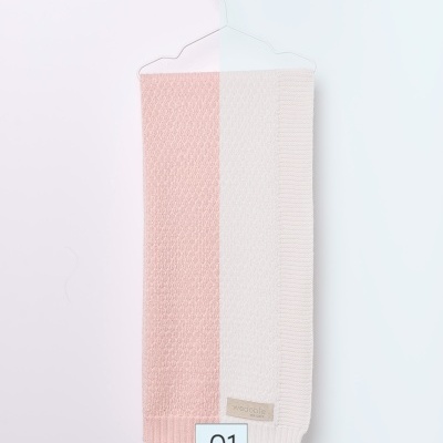 Cachecol rosa e branco em malha pendurado em cabide