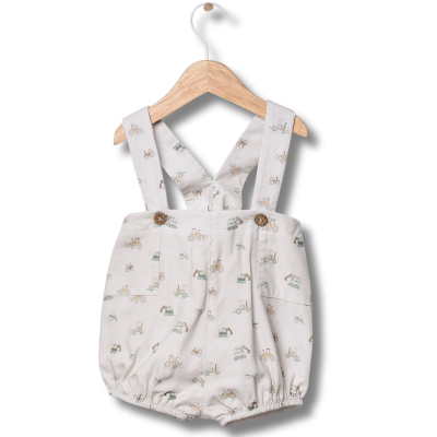 Roupa de bebé com padrão de bicicletas, alças com botões, pendurada em cabide de madeira