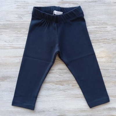 Calças de criança azul escuro sobre madeira clara