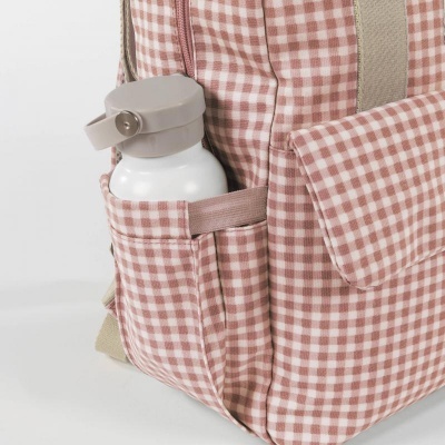 Mochila de tecido xadrez rosa e branco com garrafa branca num bolso lateral