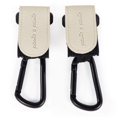 ganchos de metal preto com presilhas de tecido e abas em couro sintético bege com texto