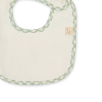 Babete branco com borda verde xadrez e etiqueta com girafa