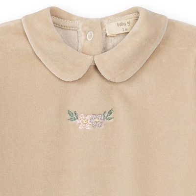 Roupa de bebé bege claro com gola redonda e bordado floral