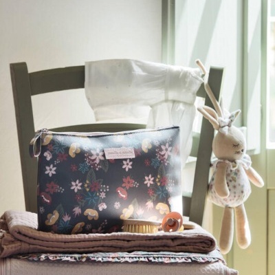 Cadeira com mantas, bolsa floral, escova de cabelo, chupeta e peluche de coelho pendurado