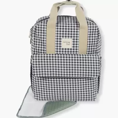 Mochila xadrez preto e branco com alças bege e acessório verde com pontos brancos