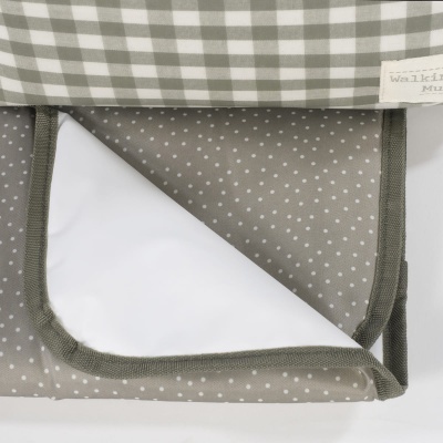 Produto têxtil com padrões de quadrados e pontos em verde e branco com etiqueta visível