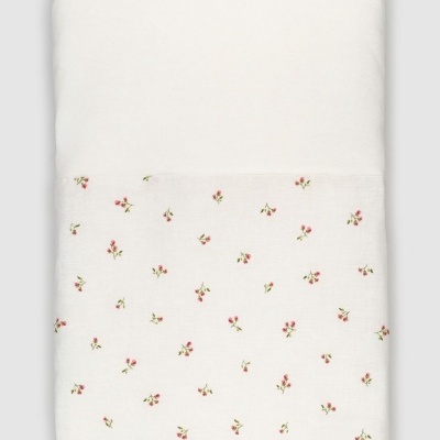 Colcha branca com pequenas flores vermelhas dobrada