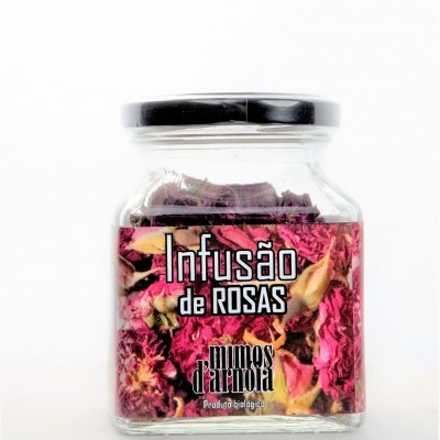 Frasco de vidro com infusão de rosas secas e rótulo rosa