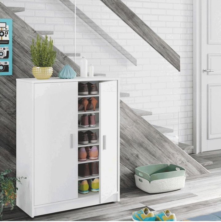 Armário branco para arrumação com prateleiras e calçado, em hall com parede branca de tijolos e escadas cinza