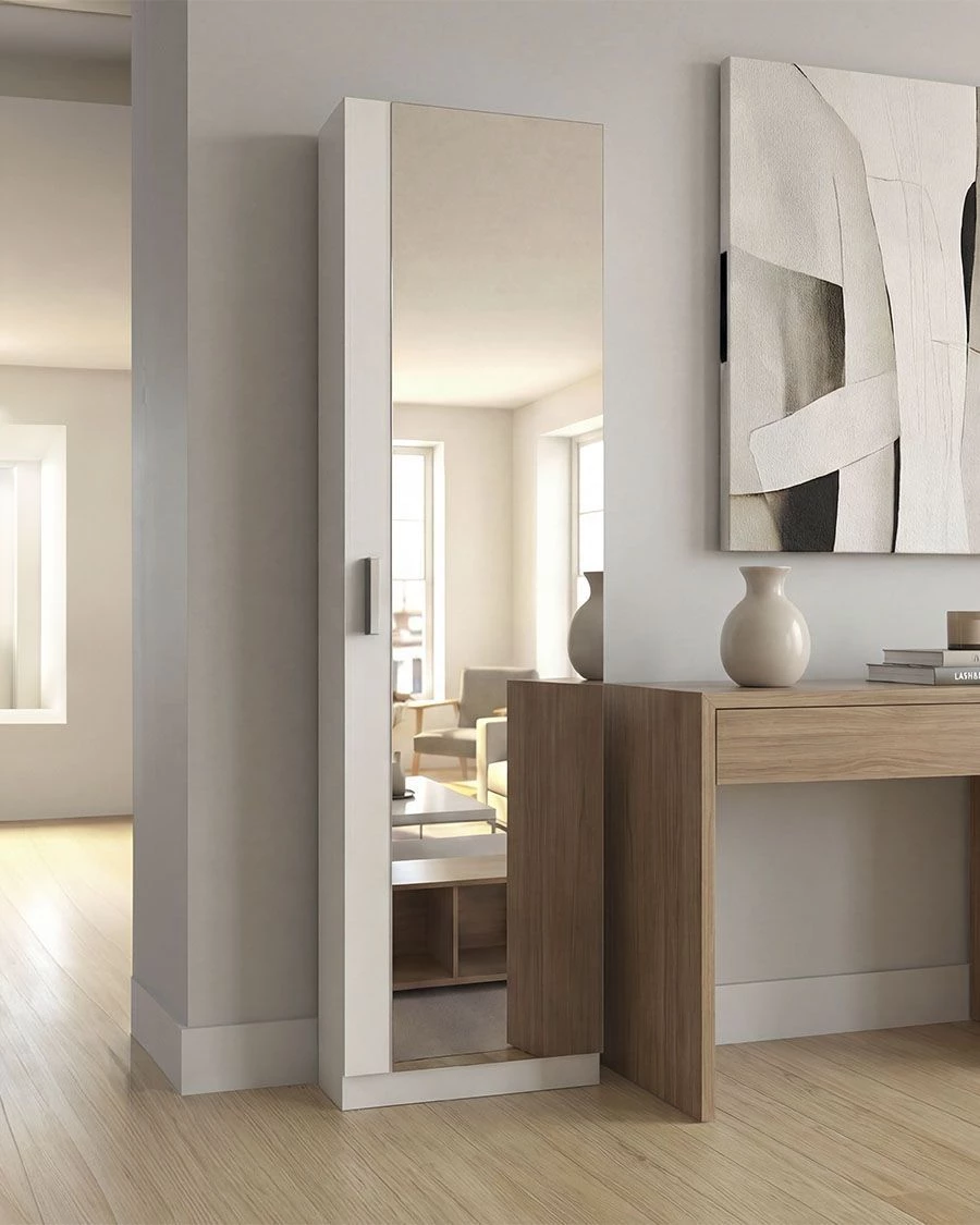 Roupeiro branco estreito com espelho numa divisão interior junto a secretária de madeira e vaso branco