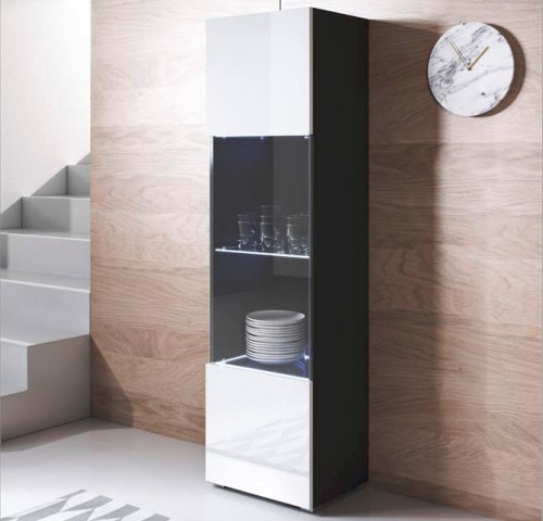 Móvel alto de cozinha preto e branco com portas de vidro exibindo louça, parede de madeira clara e relógio redondo branco