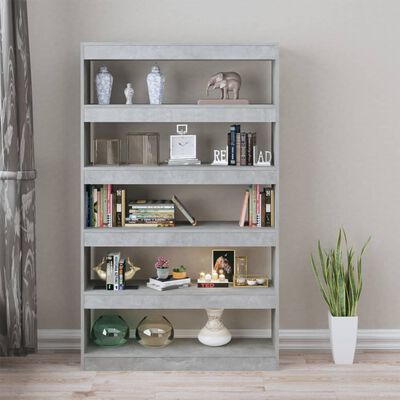Estante cinzenta com livros, objetos decorativos e planta alta ao lado