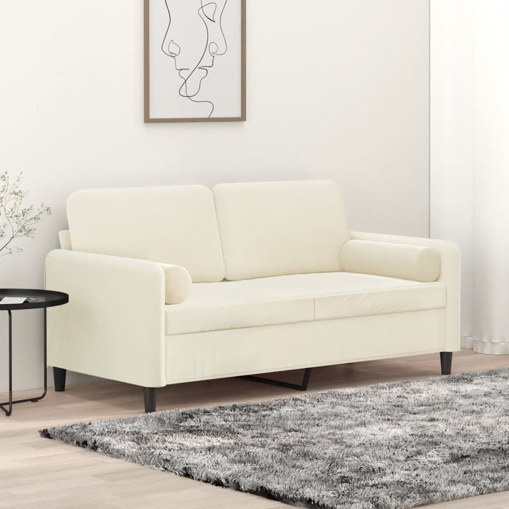 Sofá bege claro de dois lugares com almofadas e pernas pretas em ambiente minimalista