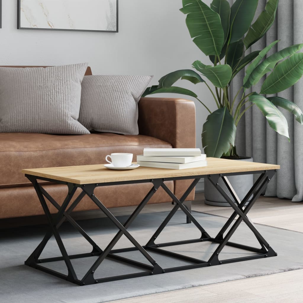 Mesa de centro madeira clara e metal preto ao lado de sofá castanho e planta verde