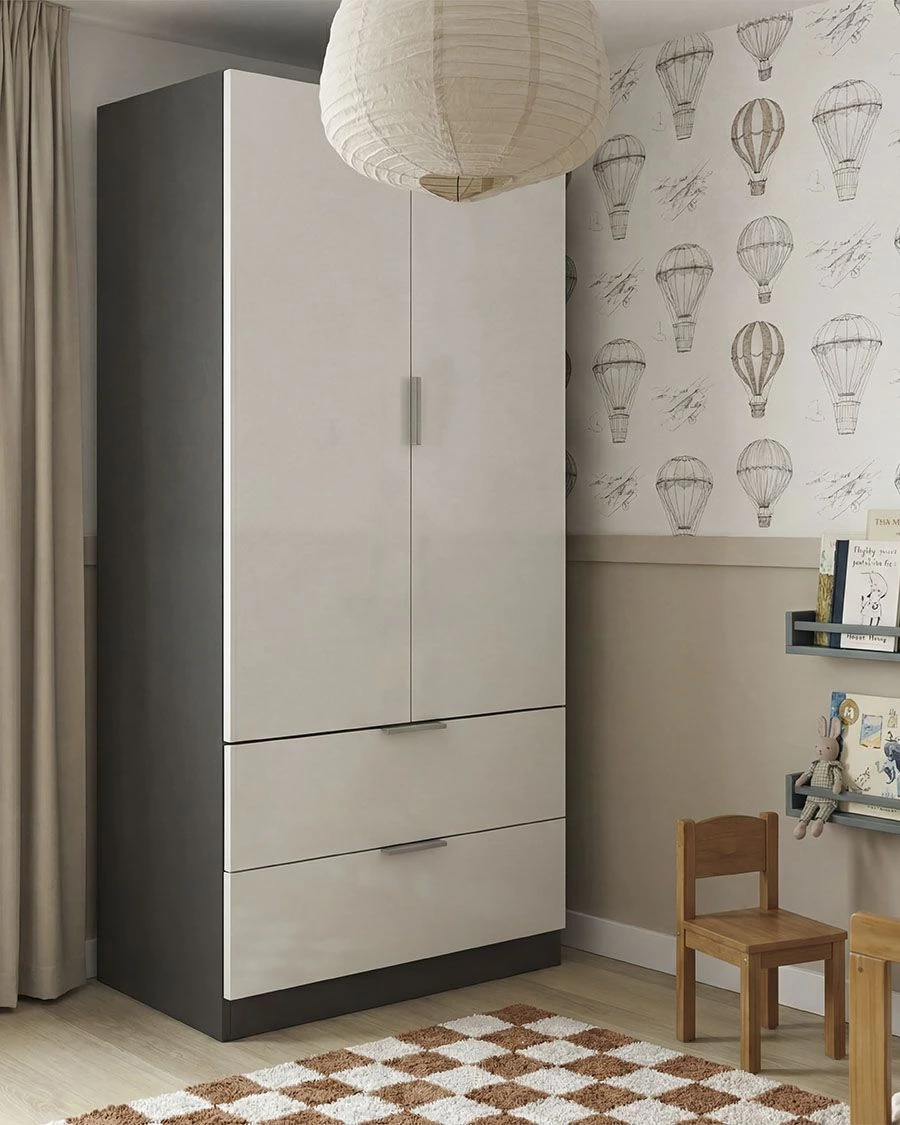 Guarda-roupa branco e cinza numa sala infantil com papel de parede de balões, tapete xadrez, cadeira de madeira e prateleiras com livros e brinquedos