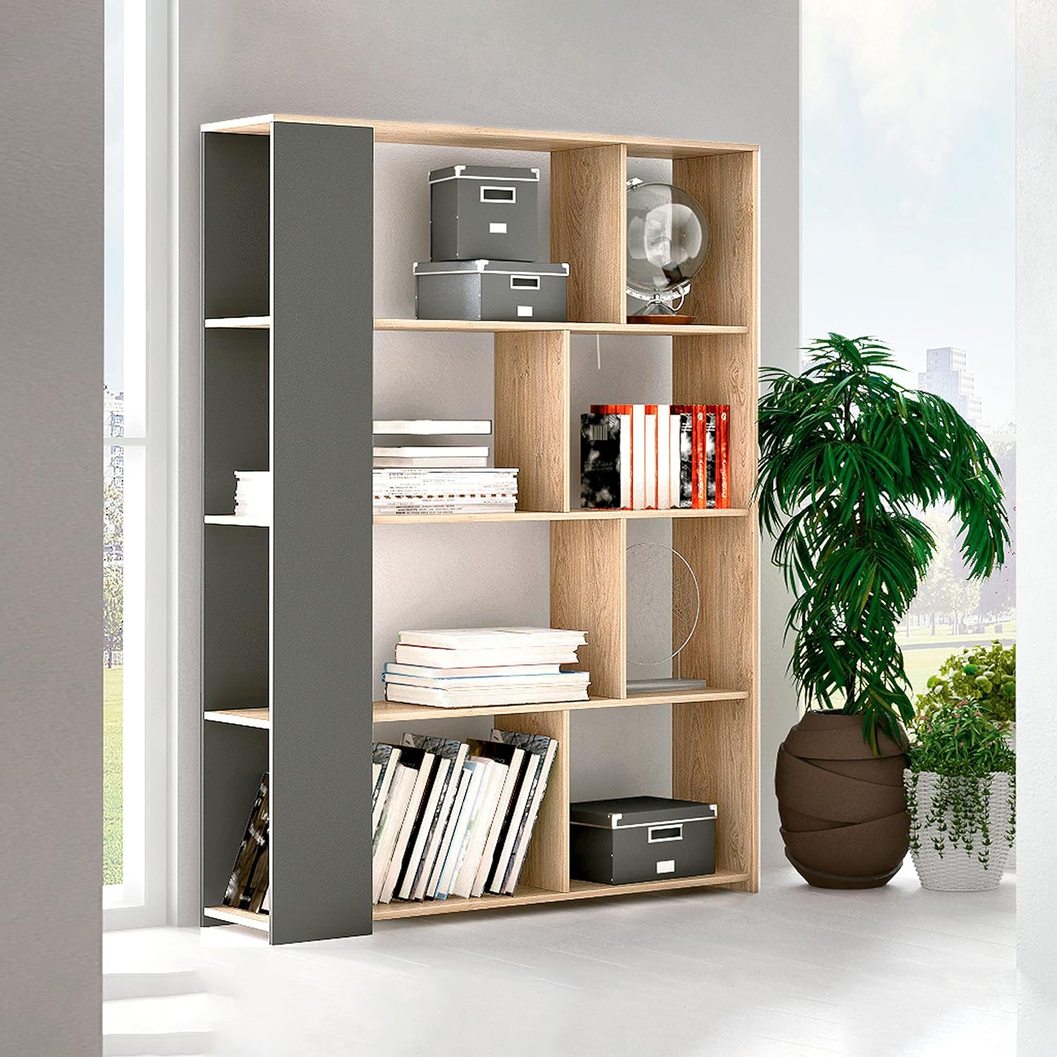 Estante em madeira clara com divisórias assimétricas e painel lateral cinzento, com caixas, livros e plantas ao lado