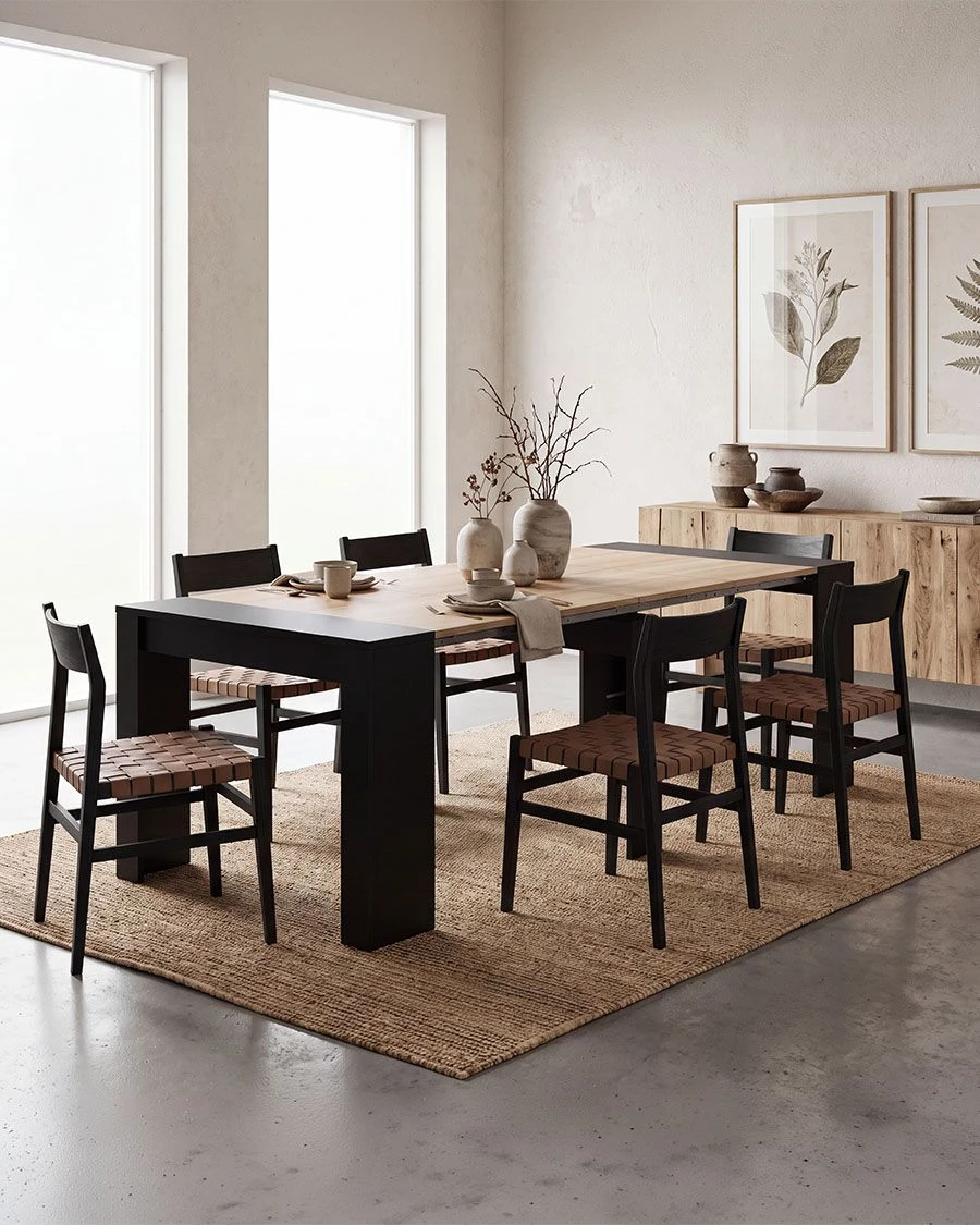 Mesa de jantar com seis cadeiras, vasos cerâmicos e decoração minimalista junto a parede com quadros botânicos
