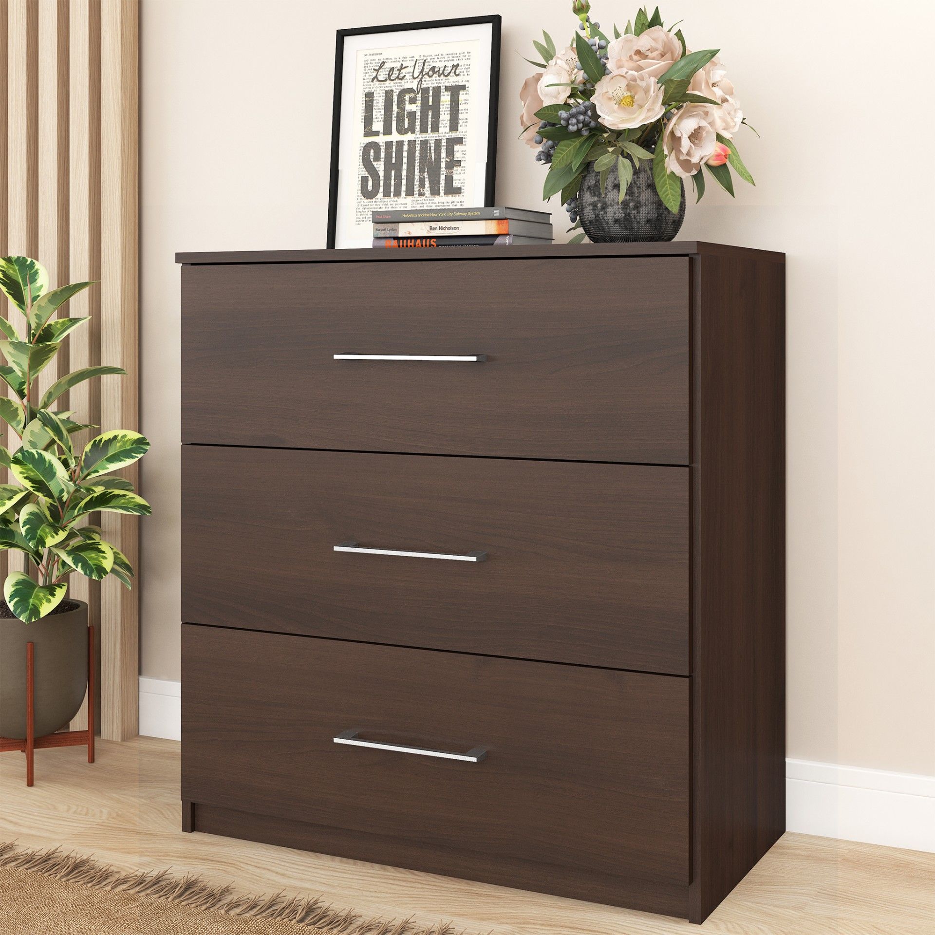 Cômoda de madeira escura com três gavetas e decoração de flores e quadro