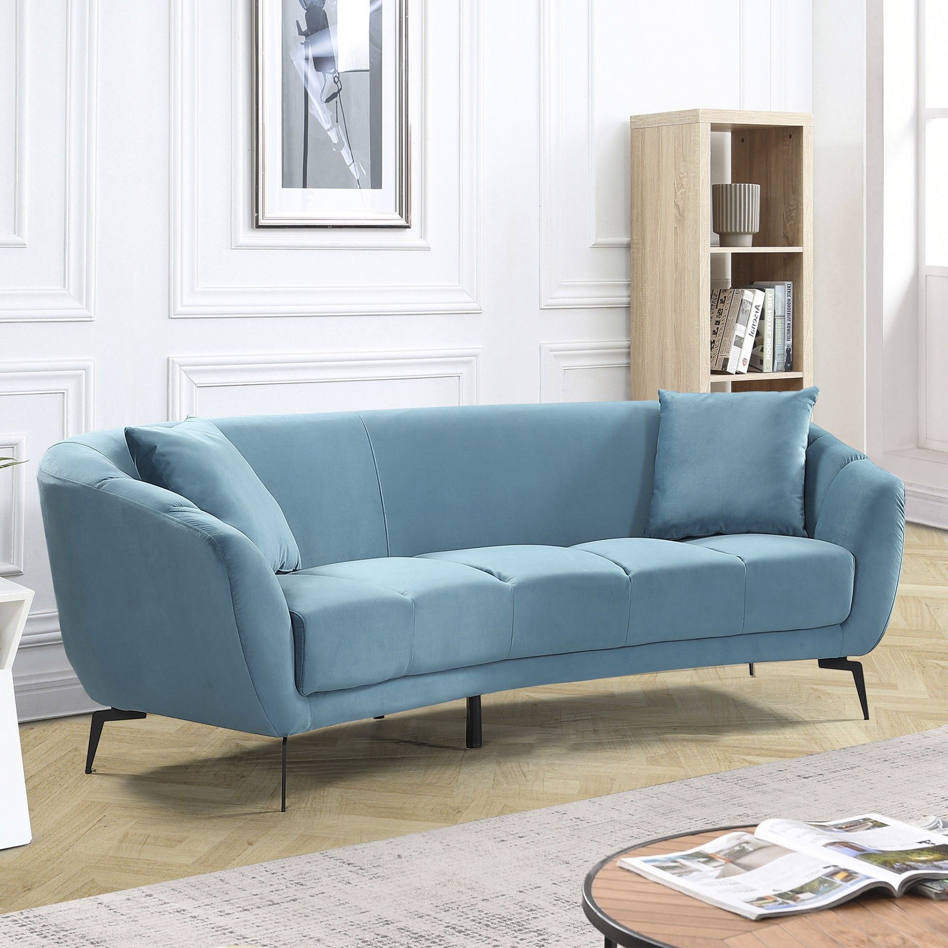 Sofá azul claro de tecido em sala com estante e mesa de centro