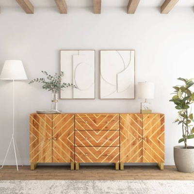 Móvel de madeira clara com padrão geométrico em V entre candeeiro de pé branco e planta em vaso, com quadros abstratos na parede